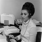 Woman at Desk with Headphones and Typewriter, Tampa, Florida, A by George Skip Gandy IV