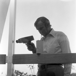 Man Using Microsonic Leak Detector on Window, C by George Skip Gandy IV