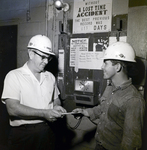 Florida Steel Employees near Timeclock and Accident Sign, C by George Skip Gandy IV