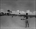 Two Men Playing Catch on a Crowded Beach, Tampa, Florida by George Skip Gandy IV