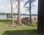 Lakeside Dock and Boat Beside Mound of Construction Dirt in Tampa, Florida, A