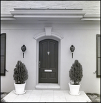 Front Door with Elegant Knocker, Two Wall Lanterns, and Potted Shrubs in Tampa, Florida, A by Skip Gandy