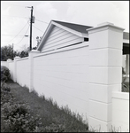 Concrete Fence Borders Landscaped Lawn and Home in Background in Tampa, Florida, B by Skip Gandy