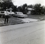 Man Standing Next to Parked Cars in Residential Neighborhood, Tampa, Florida, A by George Skip Gandy IV