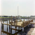 Man and Woman Standing on Dock at Mariners Pass Condominiums in St. Petersburg, B by George Skip Gandy IV