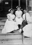 Three nurses and man with bandaged foot