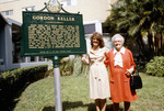 Two ladies standing by Gordon Keller monument by Gordon Keller School of Nursing