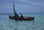 Man Sits in Small Boat on Water Near Bolanos Cay in Cayos Cochinos, Honduras