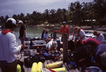 Divers Tend to Equipment on Dock in South Water Caye, Belize by John C. Ogden