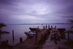 Mooring Boats to Dock with Victoria P.R. in Distance, South Water Caye, Belize by John C. Ogden