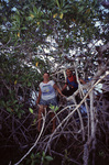 Two Researchers Smile While Navigating Through Mangroves at Twin Cays, Belize by John C. Ogden