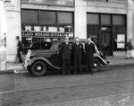 Executives stand in front of Holtsinger Motor Company by Robertson and Fresh