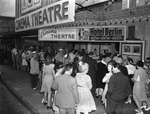Group of People Waiting Outside of the Cinema Theatre by Robertson and Fresh