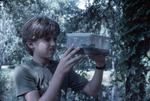 Boy Holds Container with Two Frogs at Lake Thonotosassa by University of South Florida