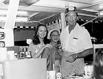 Concession Booth with Man and Two Women by Unknown