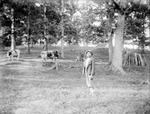 African American boy stands in a cow pasture
