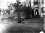 Young woman riding a bicycle down a residential street, probably in Charlottesville