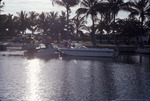Meeting of two motor boats at dock, pickup in background with additional boat on trailer by University of South Florida