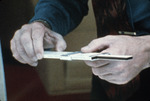 Close up of hands manipulating a slide rule by University of South Florida