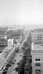 Aerial view: Central Avenue looking east toward the waterfront, the Million Dollar Pier, Yacht basin, St. Petersburg Yacht Club, Soreno Hotel, and the Ponce de Leon Hotel; the Hotel Detroit sign not visible; Willson Chase Co complete sign is legible; Deco clothing store drug store, and other businesses; many cars and people by Francis G. Wagner and Nelson Poynter Memorial Library