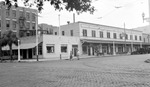 Brick street with clothing store, Palm Book Shop, Peacock Row, Williams Art Store, cars, benches, people by Francis G. Wagner and Nelson Poynter Memorial Library