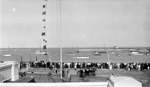 Car, flags, line of spectators at Yacht Club, watching boats in Tampa Bay; piers in background by Francis G. Wagner and Nelson Poynter Memorial Library