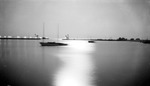 Blurry boat, looking out at Tampa Bay from the Vinoy Yacht Basin, with trees and pier buildings, Spa Beach playground