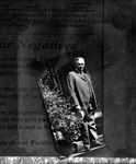 Bulletin board sign advertising enlargement of negatives, with photo of man
