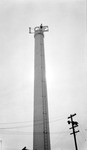 Ice company smokestack with a man standing on top, telephone pole at bottom by Francis G. Wagner and Nelson Poynter Memorial Library