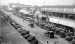 Central Avenue between 4th and 5th Street: busy brick street lined with parked cars, pedestrians, people on benches; Businesses include Hotel Preston, Pearce Drug Co., Gold Dragon Dancing by Francis G. Wagner and Nelson Poynter Memorial Library