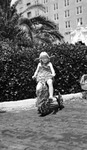 Girl on decorated tricycle next to doll carriage with sign, "St. Pete Future Housewife."; taken at the Vinoy Hotel by Francis G. Wagner and Nelson Poynter Memorial Library