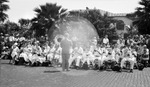 Children playing music in a band, adults standing behind them listening; Yacht Club in background by Francis G. Wagner and Nelson Poynter Memorial Library