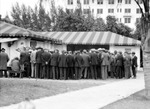 Crowd of men looking at something under large elaborate tent next to Ponce de Leon Hotel; checkerboard hanging on wall of tent by Francis G. Wagner and Nelson Poynter Memorial Library
