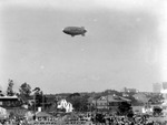 Goodyear Blimp flying over the Bayboro area of St. Petersburg, including W.A. Salter Roofing and Sheet Metal Works (600 2nd Street South), other buildings and homes; crowd of people, cars, parked planes, a banner saying "GOOD LUCK." by Francis G. Wagner and Nelson Poynter Memorial Library