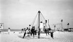 Children on swings and bars at playground, (Spa Beach), water in background by Francis G. Wagner and Nelson Poynter Memorial Library