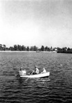 Four people in a rowboat, land in background by Francis G. Wagner and Nelson Poynter Memorial Library