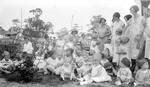 Group of children wearing hats with some women in yard; low brick wall, house in background by Francis G. Wagner and Nelson Poynter Memorial Library
