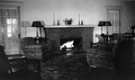 Interior: 556 19th Avenue NE. Square brick fireplace, candlesticks, lamps on tables, two overstuffed flowered chairs, wicker chairs, flowered rug, door to porch by Francis G. Wagner and Nelson Poynter Memorial Library