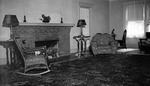 Interior: 556 19th Avenue NE. Square brick fireplace, candlesticks, lamps on tables, overstuffed flowered chairs, wicker chairs, flowered carpet, window by Francis G. Wagner and Nelson Poynter Memorial Library