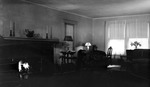 Interior: 556 19th Avenue NE. Square brick fireplace, candlesticks, lamps on tables, overstuffed flowered chair, wicker sofa, wicker chair, flowered carpet, windows, telephone by Francis G. Wagner and Nelson Poynter Memorial Library