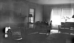 Interior: 556 19th Avenue NE. Square brick fireplace, candlesticks, lamps on tables, two overstuffed flowered chairs, wicker chairs, flowered rug, door to porch by Francis G. Wagner and Nelson Poynter Memorial Library
