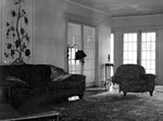Interior: 556 19th Avenue NE. French doors, overstuffed flowered chair, flowered sofa, flowered wall hanging, flowered carpet, floor lamp, small ornate table with statue by Francis G. Wagner and Nelson Poynter Memorial Library