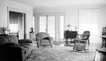 Interior: 556 19th Avenue NE. French doors, overstuffed flowered chair, flowered sofa, flowered carpet, wicker chair, lamp and statue on cabinet, window, small ornate table by Francis G. Wagner and Nelson Poynter Memorial Library
