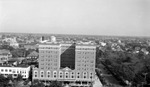Princess Martha Hotel (front view) looking north, with Dusenbury Hotel and Williams Park, cars all along 4th Street, some pedestrians, and rooftops (including Coliseum) in background by Francis G. Wagner and Nelson Poynter Memorial Library