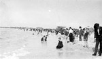 People at beach near water's edge, buildings in background by Francis G. Wagner and Nelson Poynter Memorial Library