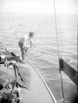 Man fishing from a sailboat, open water in background by Francis G. Wagner and Nelson Poynter Memorial Library