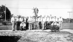 Large group of men planting tree by side of road with car in background by Francis G. Wagner and Nelson Poynter Memorial Library