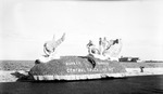 Three women riding a parade float: "Florida Safety Service: Central Truck Line Inc." ; waterfront in background by Francis G. Wagner and Nelson Poynter Memorial Library