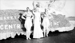 Three women posed next to a parade float by Francis G. Wagner and Nelson Poynter Memorial Library