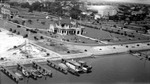 St. Petersburg Yacht Club aerial view from water, including several boats in numbered docks, cars, people, buildings to west and north in background by Francis G. Wagner and Nelson Poynter Memorial Library